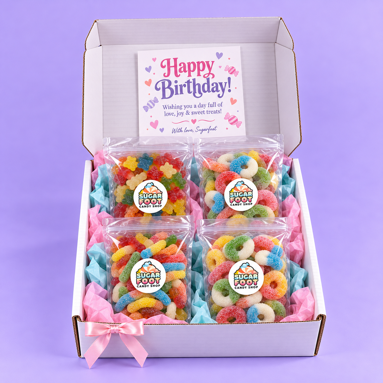 Complete open Sugarfoot Birthday Candy Box with four candy bags, colorful tissue, pink ribbon and birthday card; candy selection varies with the chosen mix